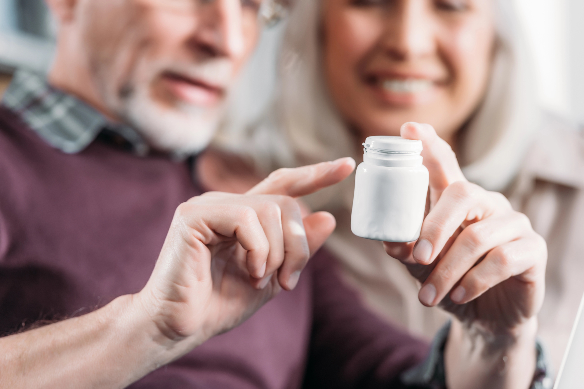 older couple holding pill bottle after online purchase of prescription drugs