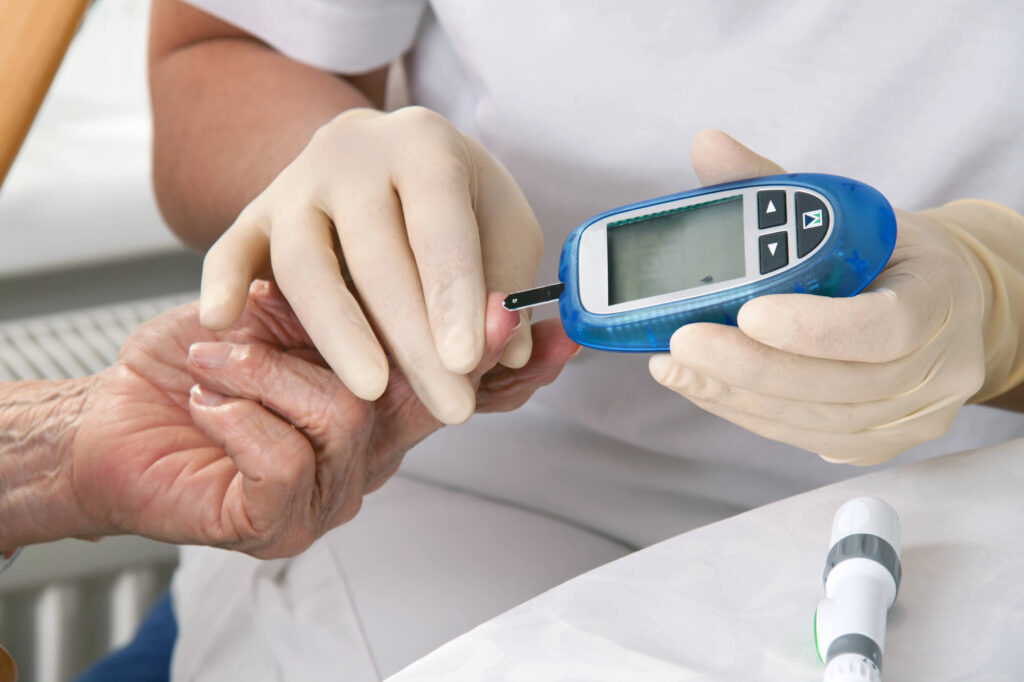 doctor measuring blood sugar levels of patient who got help with prescription drugs