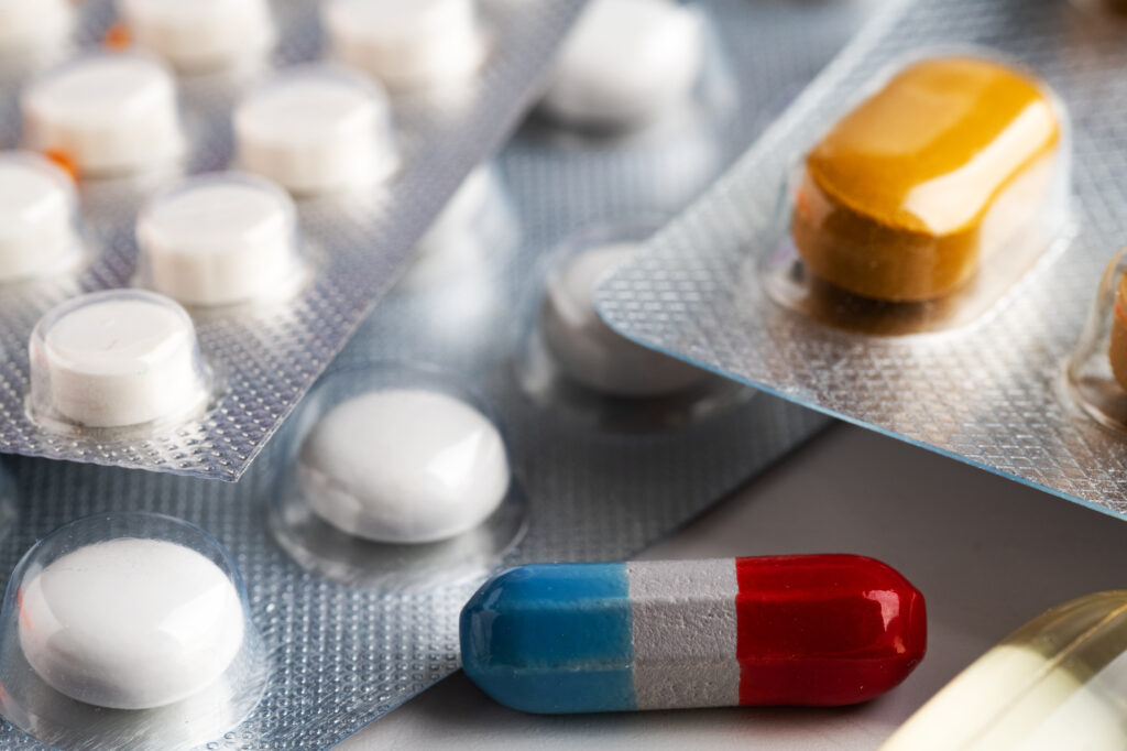 tablets and capsules pill in blister packaging arranged close-up.