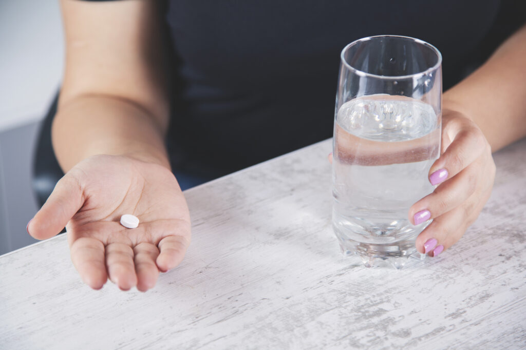 woman hand drug with water on desk